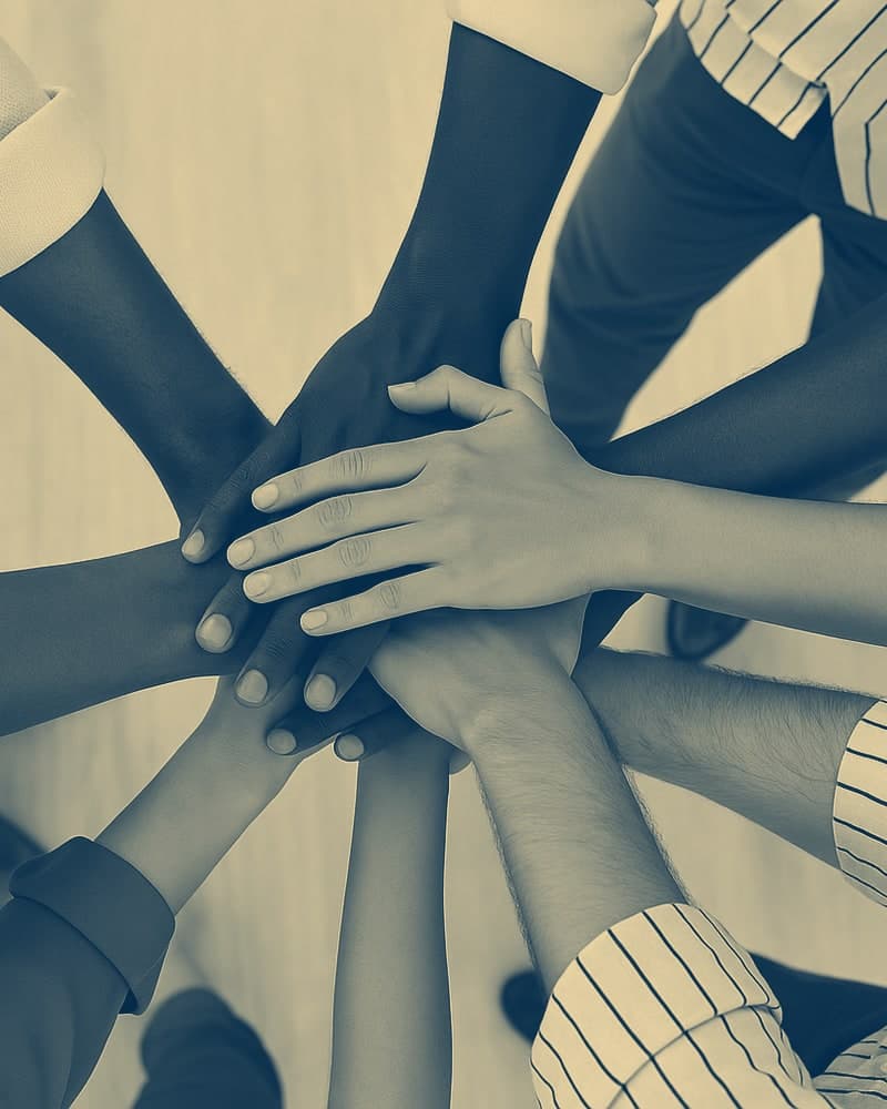 People putting their hands on top of each other as a team