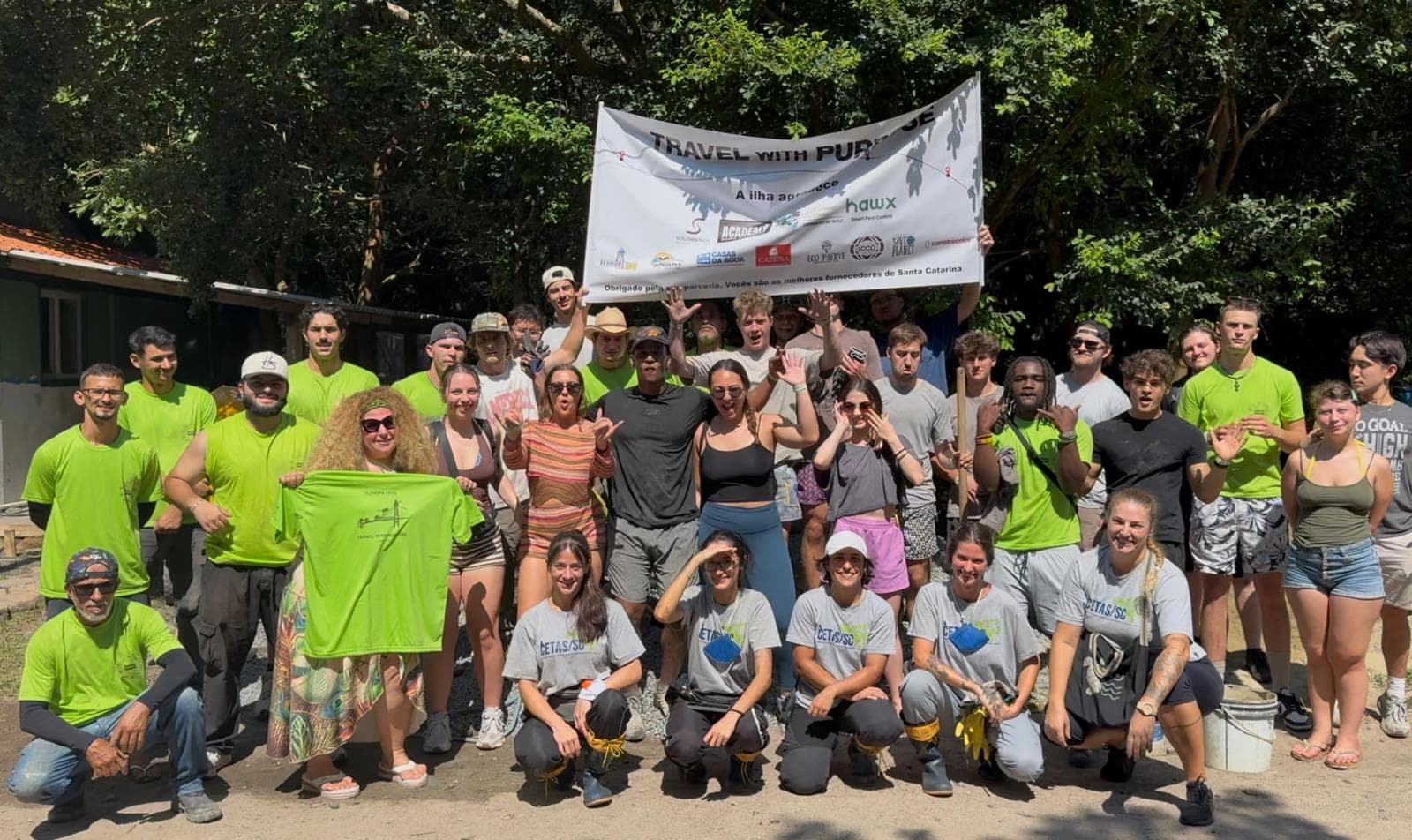A Travel with Purpose volunteer group holding their banner after a work day in Florianópolis, Brazil